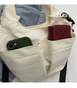 Vue détaillée d'un sac fourre-tout blanc crème avec grandes poches pour téléphone et portefeuille