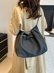 Grand sac cabas en jean gris foncé avec chaîne argentée porté par un mannequin
