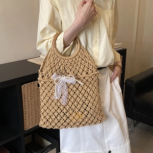 Detail of woven beach tote with round wooden handles and white lace bow ornament