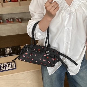 Detail of dark floral crossbody bag with silver buckles and vintage strap details