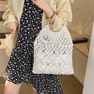 Detail of macramé woven texture with wooden handle and lace bow on a white tote bag