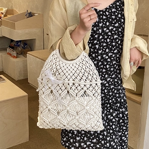 Detail of hand-woven white beach bag showing hollow diamond mesh and wooden ring handle