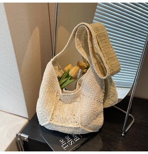 Détail du sac bandoulière en tricot crème montrant la texture crochetée et la doublure