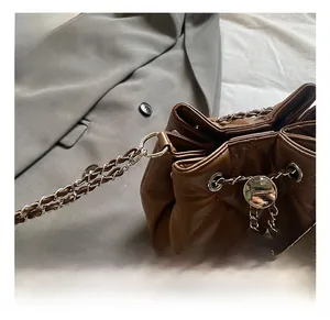 Detail showing brown quilted texture and silver chain strap on fashion bucket bag