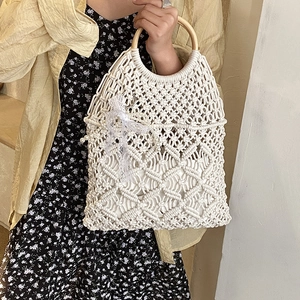 Detail of hand-woven cream tote with floral patterns, wooden handle, lace bow and pearls