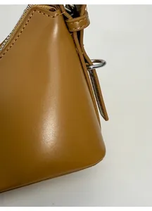Macro di una borsa in similpelle marrone con cuciture e anello a D in metallo argento