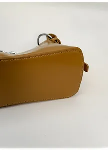 Dettaglio della base ampia e delle cuciture di questa borsa a mezzaluna in pelle marrone