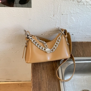 Detail of khaki crescent shoulder bag featuring a chunky silver chain and metal disk