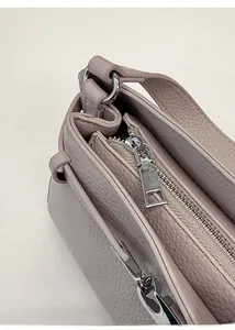 Detail of light purple litchi grain leather texture and smooth silver metal zipper closure