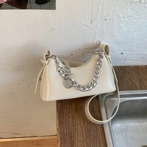 Detail of hobo shoulder bag featuring thick silver chain and smooth beige leather texture