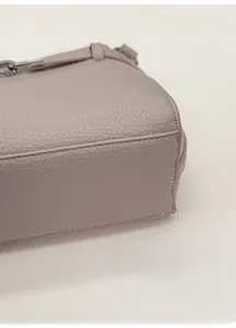 Detail of lychee pattern leather base and neat stitching on a luxury handbag