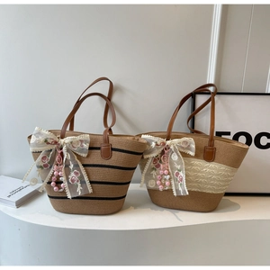 Détails de sacs cabas en paille tressée avec poignées en cuir et grands nœuds en dentelle