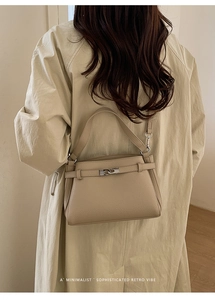 Close-up of the beige pebble leather texture and silver turn-lock on the shoulder bag