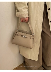 Detail of minimalist beige lychee pattern leather bag with silver metal hardware buckle