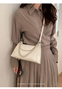 Close-up of cream lychee texture crossbody bag with elegant chain flap detail