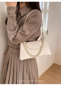 Detail of cream white leather hobo bag with chunky chain strap and pebble grain texture