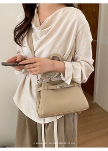 Detail shot of the beige lychee pattern leather texture and silver buckle on this bag