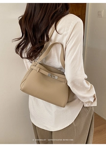 Detail showing the retro khaki pebble leather texture and metallic buckle on the bag