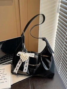 Black glossy moon-shaped shoulder bag with pearl heart charm and lace bow detail