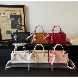 Group display of crocodile pattern handbags in six colors with silk scarf wrapped handles