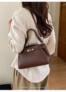 Macro shot of brown leather texture and silver metal interlocking clasp on a satchel