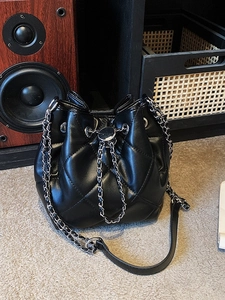Classic black quilted bucket bag with drawstring closure and metal chain strap
