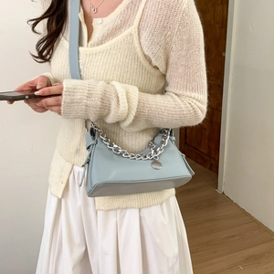 Close-up of light blue leather baguette bag with chunky silver chain and strap