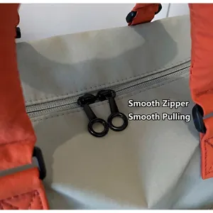 Detail of smooth metal zippers on grey ripstop fabric of this large travel bag