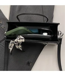 Interior view of black crocodile pattern bag with zipper compartment and silk scarf detail