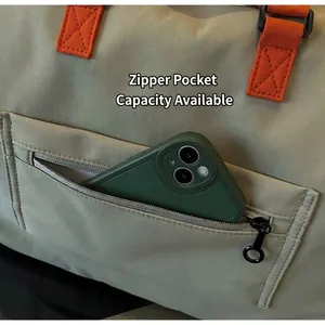 Detail view of khaki travel bag showing side zipper pocket with a smartphone inside