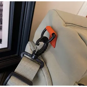 Detail of durable black hook with silver metal buckle on grey travel bag strap