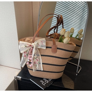 Détail du sac cabas en paille à rayures noires, nœud en dentelle florale et perles