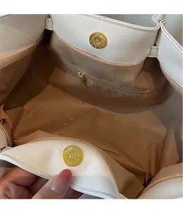 Detail of light beige tote bag interior with fabric lining and golden magnetic closures