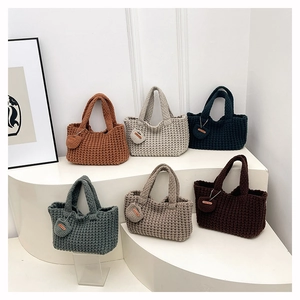 Bolsos tote de ganchillo hechos a mano en seis colores en un soporte blanco de niveles
