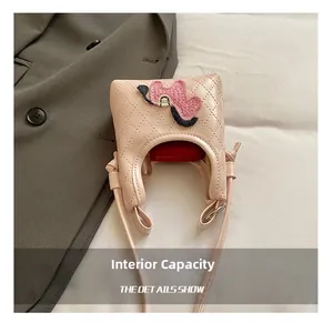 Pink quilted mini crossbody bag showing internal space for a single lipstick