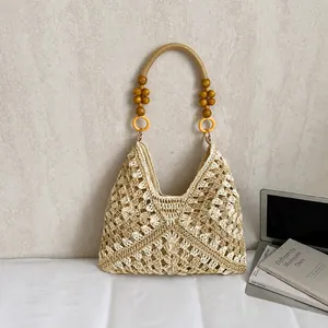 Detalle de bolso shopper de ganchillo con patrones tejidos y asas de cuentas de madera