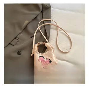 Macro detail of pink quilted mini crossbody bag featuring cute pony embroidery and PU texture