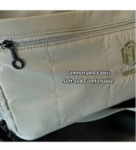 Close-up of khaki ripstop nylon travel bag with metal zipper and green NING embroidery