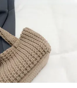 Close-up of brown knit handbag showing soft thick yarn texture and woven details