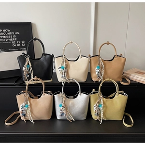 Detailed display of six bucket bags with silk scarves and bear charms on a stand