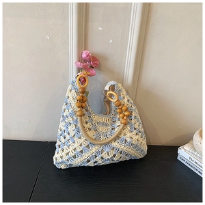 Dettaglio della borsa tote intrecciata blu e bianca con manico in perline di legno