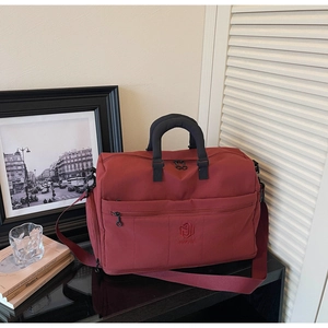 Detail of burgundy travel bag showing high-density nylon fabric and NINGJIA logo