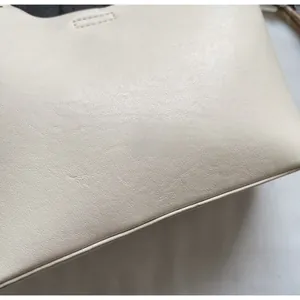 Close-up of beige leather texture with fine stitching on the stylish bucket bag