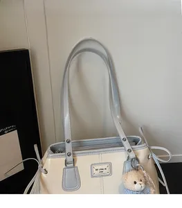 Detail of light blue faux leather straps and metal zipper on a beige tote bag