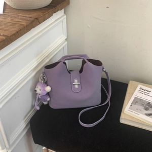 Détail du sac seau violet clair avec fermoir rotatif argenté et charmant ours décoratif