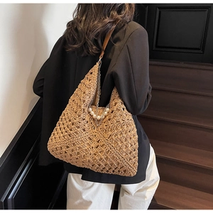 Détail d'un sac en paille avec chaîne en perles élégante et design en maille ajourée