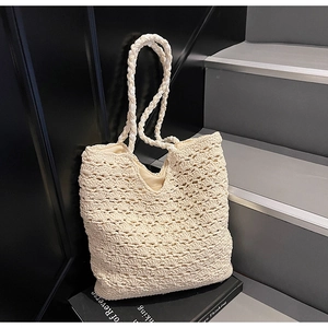 Detail of hollow woven texture and shoulder straps on a beige crochet tote bag