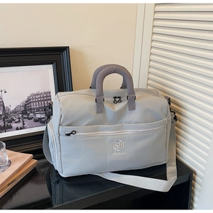 Detail of light grey large travel duffel bag with reinforced handles and NINGJIA logo