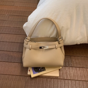 Dettaglio della borsa beige in pelle a grana con fibbia metallica e manico singolo