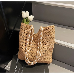 Detailed close-up of woven hollow pattern and dual-tone rope handle on beige tote bag